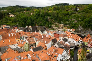 Kilisenin ünlü Cesky Krumlov Şatosu 'nun bulunduğu tarihi Cesky Krumlov şehrinin yukarıdaki panoramik manzara manzarası, ilkbaharda güzel bir gökyüzü ve bulutlarla yakalanan UNESCO Dünya Mirası Alanında yer alıyor.
