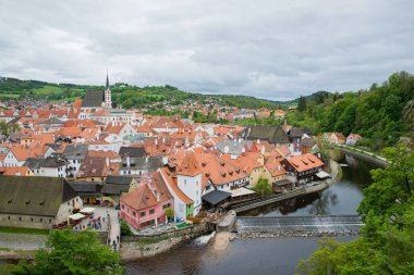 Kilisenin ünlü Cesky Krumlov Şatosu 'nun bulunduğu tarihi Cesky Krumlov şehrinin yukarıdaki panoramik manzara manzarası, ilkbaharda güzel bir gökyüzü ve bulutlarla yakalanan UNESCO Dünya Mirası Alanında yer alıyor.