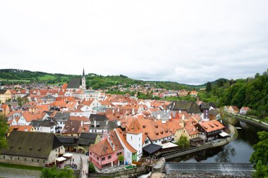 Kilisenin ünlü Cesky Krumlov Şatosu 'nun bulunduğu tarihi Cesky Krumlov şehrinin yukarıdaki panoramik manzara manzarası, ilkbaharda güzel bir gökyüzü ve bulutlarla yakalanan UNESCO Dünya Mirası Alanında yer alıyor.