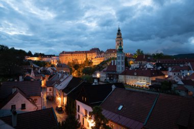 Günbatımında ünlü Cesky Krumlov Şatosu ile birlikte tarihi Cesky Krumlov şehrinin panoramik manzara manzarası, güzel gökyüzü ve bulutlarla kaplanmış UNESCO Dünya Mirası Bölgesi üzerindedir.