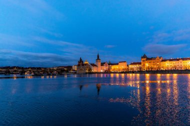 Prag Çek Cumhuriyeti 'nin merkezi ve Vltava nehri üzerindeki en büyük simgesi Charles Köprüsü ve güzel rıhtım kıyısı gün batımında aydınlandı..