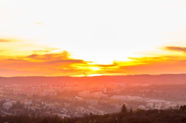Gün batımından birkaç dakika önce Brno Hill 'den doğaya ve manzaraya tepeden bakan turuncu renkli bulutlar arka planda hareket ederken ve gökyüzünde uçan uçaklar....