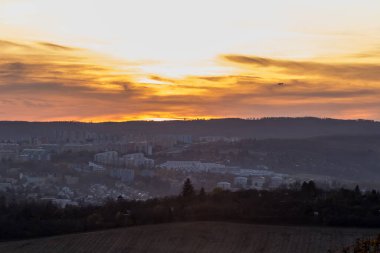 Gün batımından birkaç dakika önce Brno Hill 'den doğaya ve manzaraya tepeden bakan turuncu renkli bulutlar arka planda hareket ederken ve gökyüzünde uçan uçaklar....