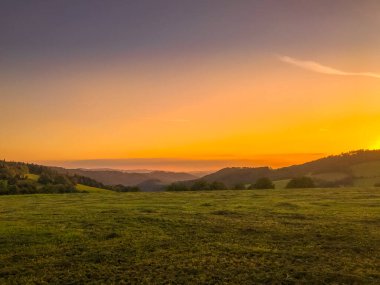 Tepenin çok renkli gökyüzü Velka Lhota Beskydy alan gökyüzü ve bulutlar gün batımında etrafındaki küçük tepeler ve dağları çevreleyen doğa alanını çevreleyen birçok renkle oynarlar..