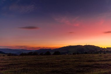 Tepenin çok renkli gökyüzü Velka Lhota Beskydy alan gökyüzü ve bulutlar gün batımında etrafındaki küçük tepeler ve dağları çevreleyen doğa alanını çevreleyen birçok renkle oynarlar..