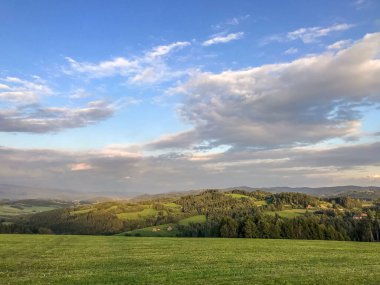 Gökyüzünde bulunan beyaz bulutlar, Çek Cumhuriyeti 'nin Beskydy bölgesindeki Krhova köyünde, güneşli bir günde toprak ve manzara üzerinde yansıyan küçük bir köyün hızlandırılmış görüntüsü olarak ele geçirildi..