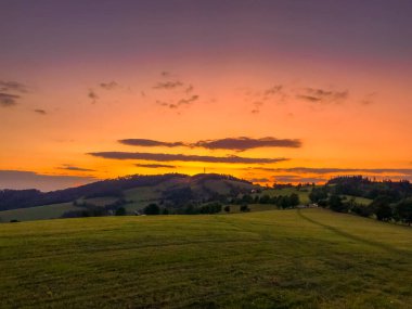Tepenin çok renkli gökyüzü Velka Lhota Beskydy alan gökyüzü ve bulutlar gün batımında etrafındaki küçük tepeler ve dağları çevreleyen doğa alanını çevreleyen birçok renkle oynarlar..