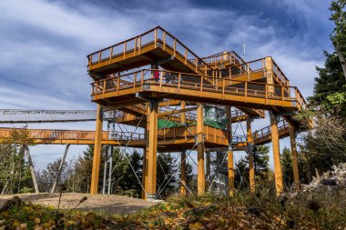 Beskydy Pustevny ve bölgedeki bulutların ahşap yapının manzarası insanların arka planda bulutlarla ve gökyüzüyle birlikte yürüdüğünü gösteriyor.