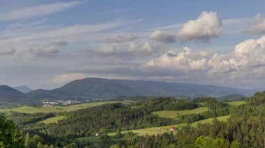 Bulutların zamanlaması doğanın ve dağlarla dolu bir çevrede evlerle ve Beskydy Çek Cumhuriyeti manzarasının vadisinde uzanan bir köyle birlikte hareket ediyor..