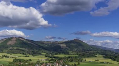 Ondrejnik dağlarının tepelerinde Kozlovice köyü dağın altında uzanırken tepelerin ve gölgelerin üzerinden hareket eden bulutlar orman manzarasını yansıtarak değiştiriyor..