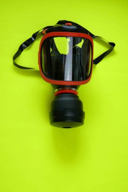 Filtreli koruyucu maske. Parlak sarı neon arka planda solunum cihazı olan güvenlik maskesi