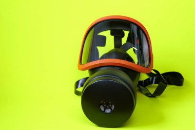 Filtreli koruyucu maske. Parlak sarı neon arka planda solunum cihazı olan güvenlik maskesi