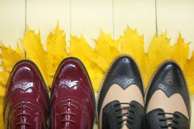 Sarı akçaağaç yapraklarındaki sonbahar ayakkabıları sarı ahşap arka planda. Sonbahar sezonu.