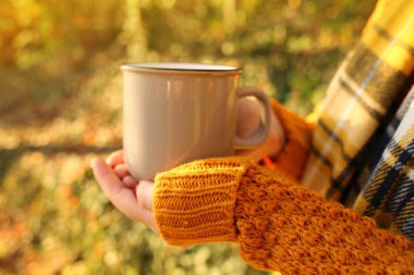 Sonbahar kahvesi. Sonbahar çayı. Bulanık sebze arka planında bir fincan sıcak içecek.