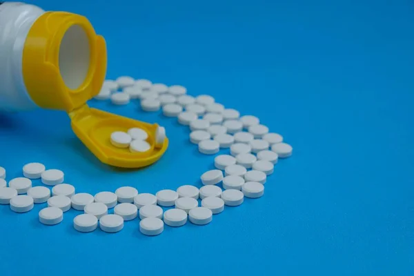 Weiße Pillen Einer Medizinflasche Mit Gelbem Deckel Auf Blauem Hintergrund — Stockfoto