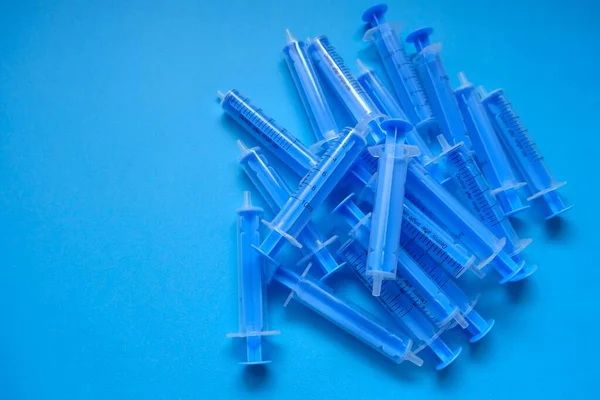 Medizin Und Gesundheitskonzept Blaue Plastikspritzen Großaufnahme Auf Blauem Hintergrund — Stockfoto