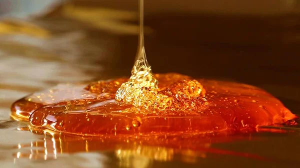 Flüssiger Honig Auf Goldenem Verschwommenem Hintergrund — Stockfoto