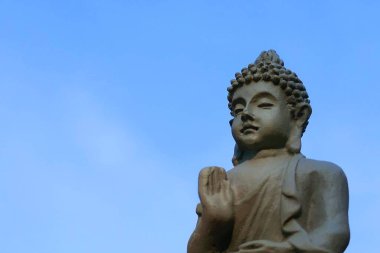 Mavi gökyüzü arka planında Buda heykeli