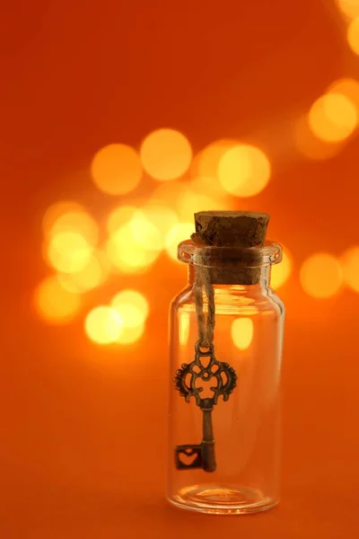 Klucz Butelce Błyszczącym Żółtym Bokeh Pomarańczowym Tle — Zdjęcie stockowe