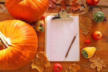 Balkabağı ve not defteriyle sonbahar arkaplanı 