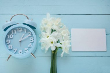 Bahar geldi. Mavi alarm saati, bir buket beyaz nergis. 