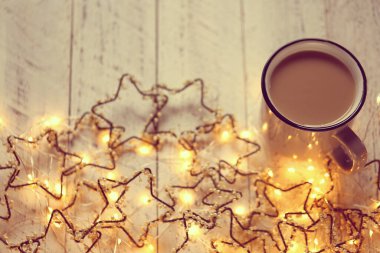 Kış havası. Kahverengi kahve fincanı ve parlak bir çelenk. Eski püskü, parlak bir arka planda.