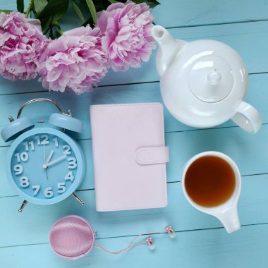 Masada pembe defter, çay fincanı ve mavi penis var. 