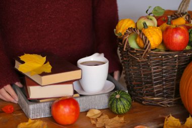 Kitaplar, bir fincan çay ve balkabağı. 