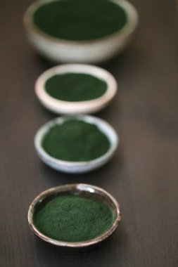 Zeytinyosunları. Yuvarlak bardaklardaki toz .organik spirulina alg tozu. Süper yemek konsepti.