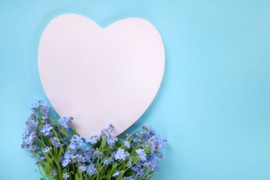 Çiçek kartı. Unutma beni çiçekleri ve içi boş kalbi.