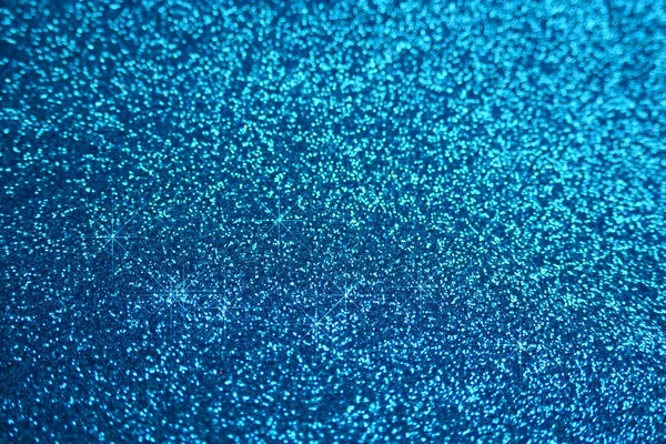 Blue glitter background with light blue shining bokeh
