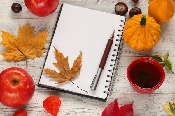 Düşen yapraklar ve not defteriyle sonbahar arkaplanı