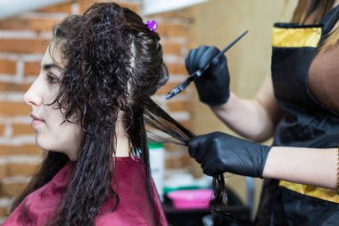 Kuaför müşterinin saçına profesyonel sıvı keratin uygular. Bir kız kuaförde keratin saç güçlendiriyor. Saç bakımı.
