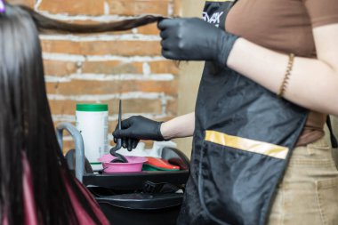 Kuaför müşterinin saçına profesyonel sıvı keratin uygular, yakın plan. Kuaförde Keratin saç düzleştirme / güçlendirme.