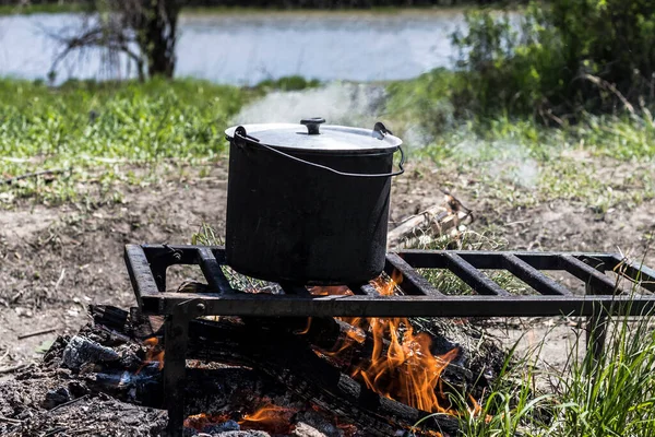 stock image Cooking in a pot over an open fire during a hike.