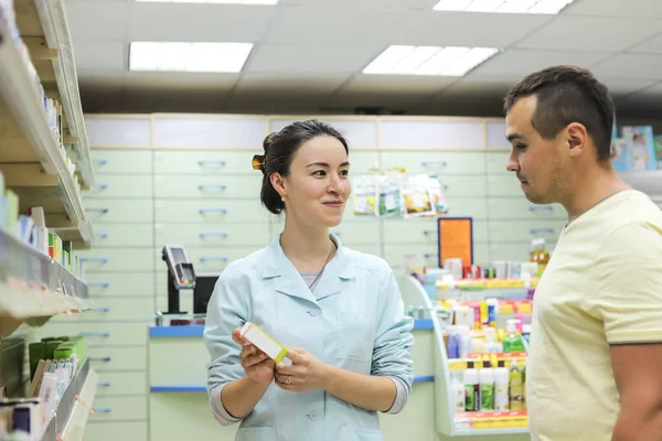 Vrouwelijke Apotheker Met Medicijn Hand Adviseert Klant Man Koopt Pillen — Stockfoto