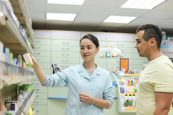 Vrouwelijke Apotheker Met Medicijn Hand Adviseert Klant Een Man Koopt — Stockfoto