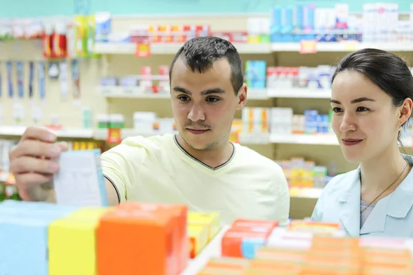 Een Vrouwelijke Apotheker Adviseert Cliënt Keuze Van Geneesmiddelen Een Man — Stockfoto