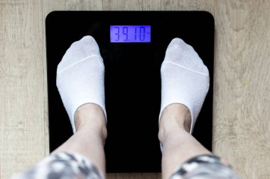 Yerdeki kadın ayakları, üst manzara. Kilogram olarak dış ağırlıkların ağırlık göstergesi. Uygun beslenme ve kilo kaybı kavramı.