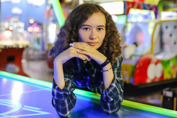 Beautiful girl leaned against the air hockey table
