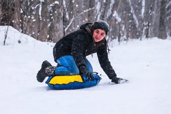 Fröhlicher Typ Rollt Auf Snow Tubing Wald Den Hügel Hinunter — Stockfoto