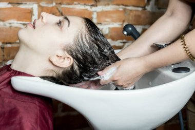 Berber, müşterinin saçındaki şampuanı güzellik salonundaki lavaboda yıkar..