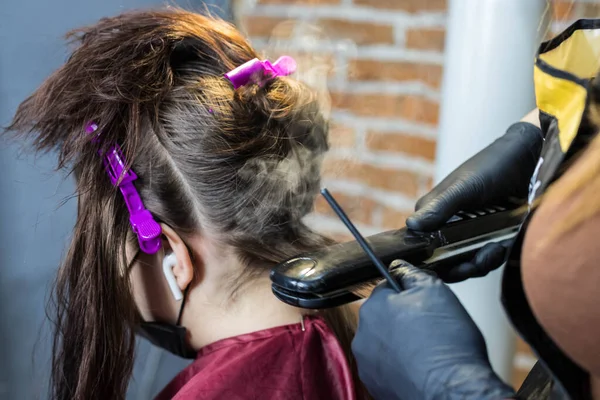 Sealing hair with keratin using a straightening iron. The formation of the keratin fibers.