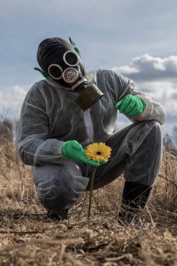Gaz maskeli yeşil kulaklı bir Marslı Dünya gezegenini inceliyor. Sarı çiçekli bir uzaylı. Dünya dışı bir varlık..