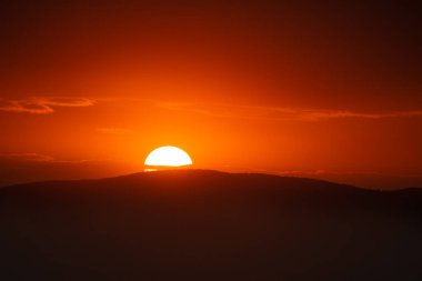 Bulutların üzerinde dramatik bir ışıkla gün batımı..