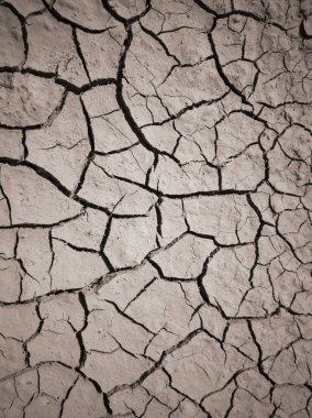 Kuru çatlamış toprak dokusu. Çöl arka planı. Küresel su sıkıntısı. Sıcak iklim ve kuraklığın sembolü olarak kahverengi topraklardaki derin çatlaklar.