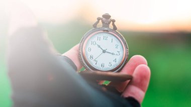 Elinde eski bir cep saati