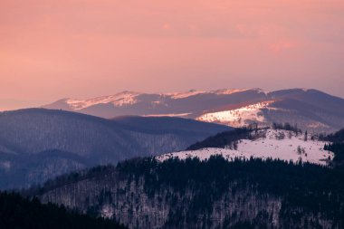 Romanya 'daki renkli sisli dağlarda görülebilir siluetlerle dağ sıraları. Tarcu Dağları.