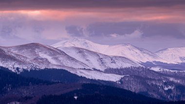 Romanya 'daki renkli sisli dağlarda görülebilir siluetlerle dağ sıraları. Tarcu Dağları.