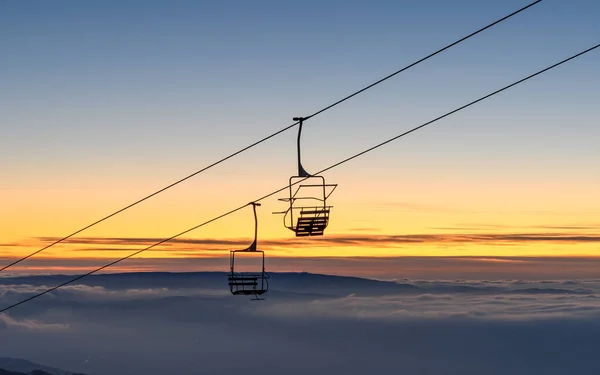 Caras Severin, Romania. chairlift that climbs the small mountain in the evening at sunset.